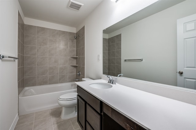 full bathroom featuring vanity, tiled shower / bath, tile patterned floors, and toilet