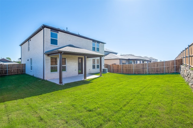 rear view of house with a lawn, central AC, and a patio