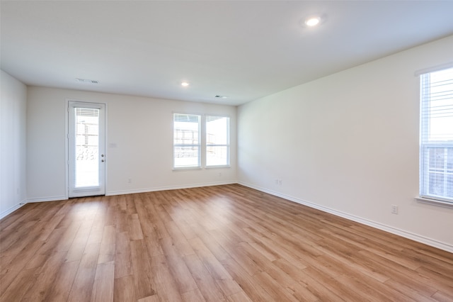 unfurnished room with plenty of natural light and light hardwood / wood-style flooring