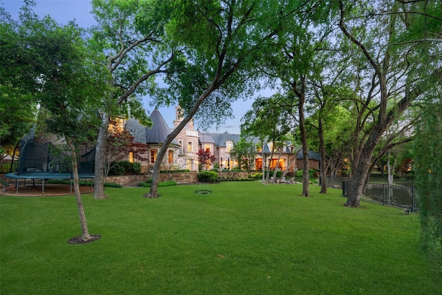 view of home's community featuring a yard and a trampoline