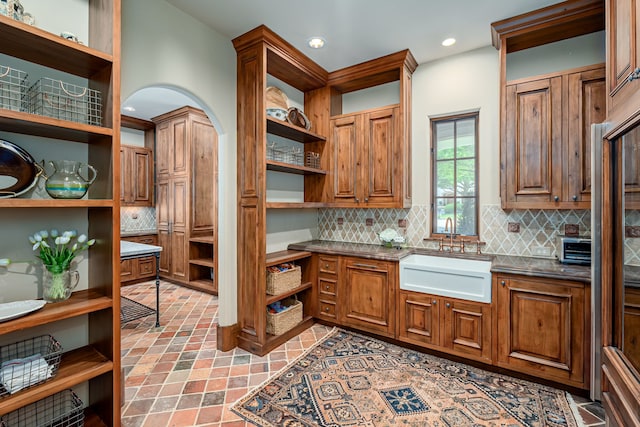 kitchen with tasteful backsplash, sink, and dark stone counters