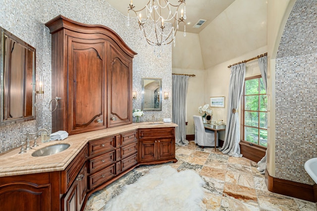 bathroom with vanity, a washtub, a towering ceiling, and a chandelier