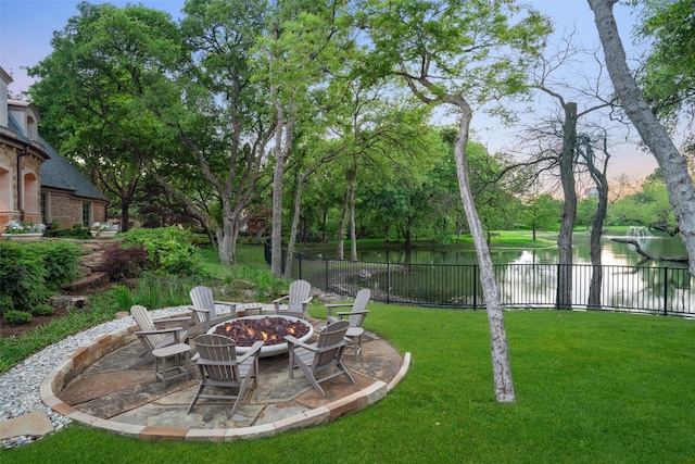 view of yard with a water view, an outdoor fire pit, and a patio