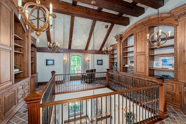 interior space with vaulted ceiling with beams and an inviting chandelier