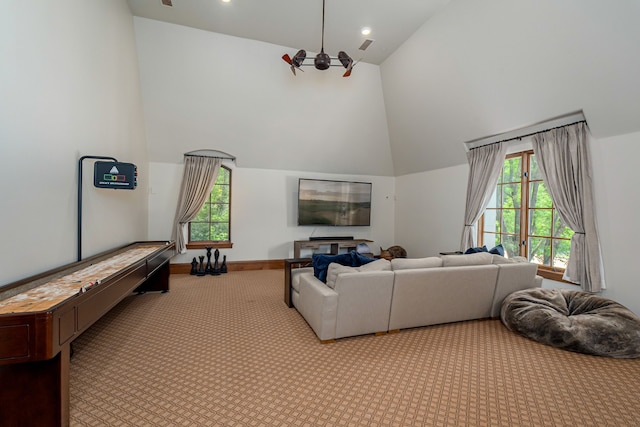 carpeted living room featuring plenty of natural light and high vaulted ceiling