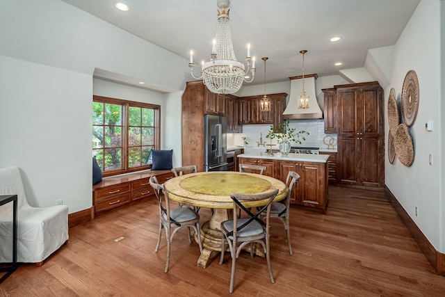 kitchen featuring custom exhaust hood, a center island, hanging light fixtures, high quality fridge, and backsplash