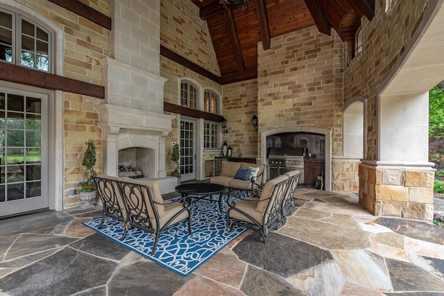 view of patio / terrace with grilling area, a fireplace, and an outdoor kitchen