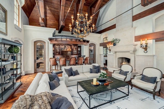 living room with beam ceiling, a towering ceiling, wooden ceiling, and a high end fireplace