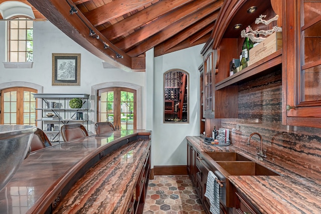 dining area with french doors, sink, vaulted ceiling with beams, wood ceiling, and track lighting