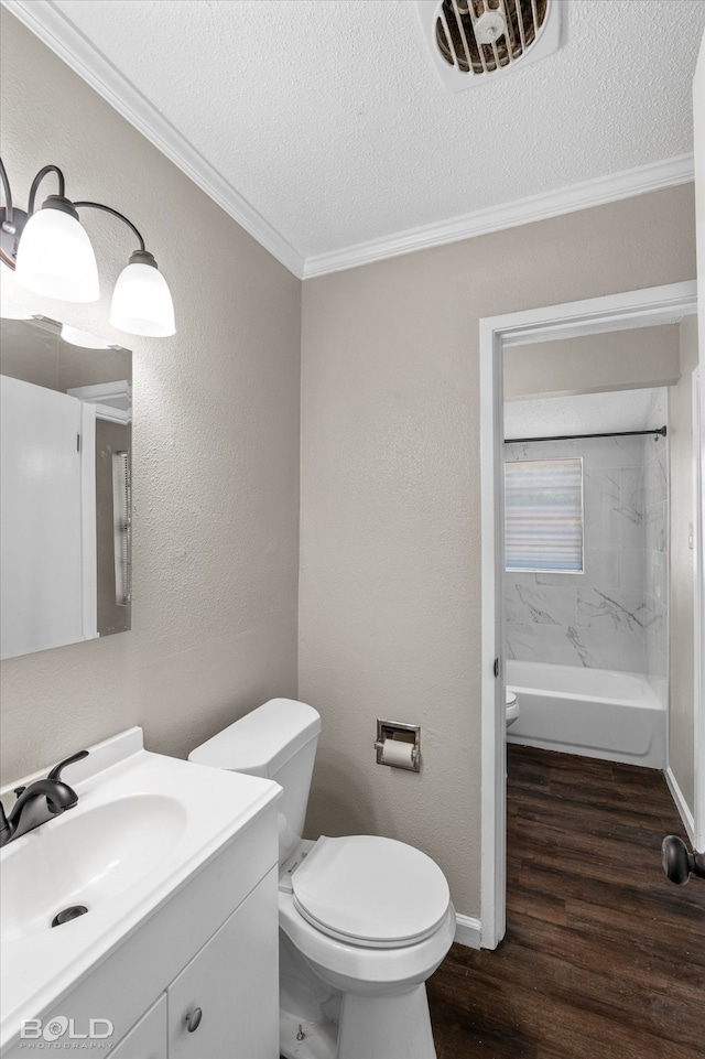 bathroom with hardwood / wood-style floors, a textured ceiling, toilet, vanity, and ornamental molding