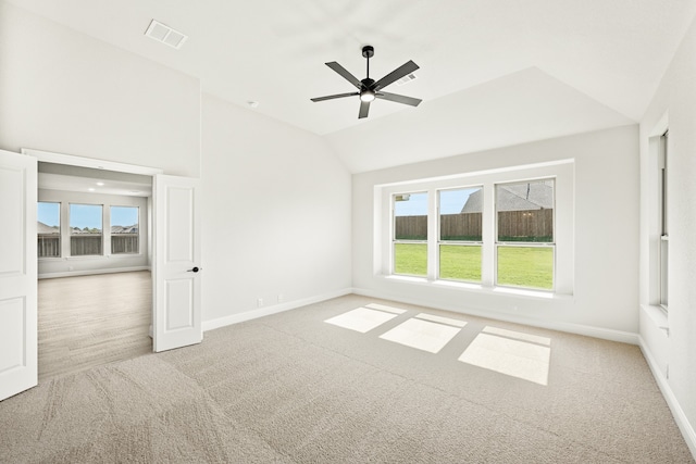 spare room with ceiling fan, a healthy amount of sunlight, lofted ceiling, and light carpet