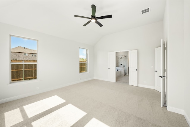 interior space featuring ceiling fan, light colored carpet, and lofted ceiling