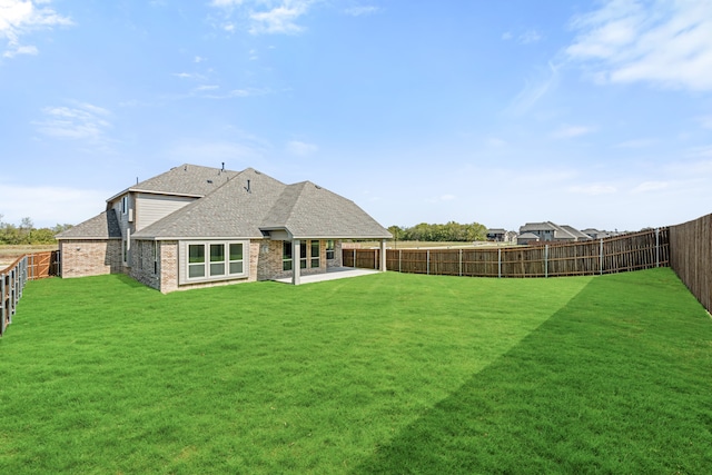 rear view of property with a lawn and a patio area