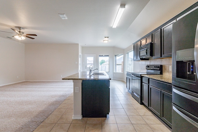 kitchen with a center island with sink, electric stove, decorative backsplash, and light tile patterned flooring