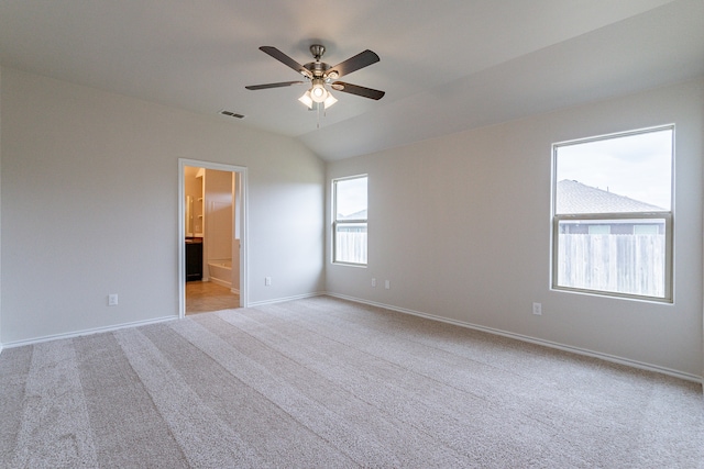 carpeted spare room with vaulted ceiling and ceiling fan