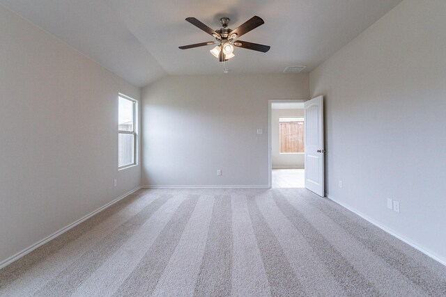 spare room featuring ceiling fan, lofted ceiling, and light colored carpet