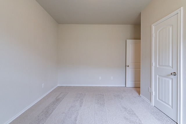 spare room featuring light carpet