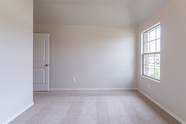 spare room featuring plenty of natural light and light colored carpet