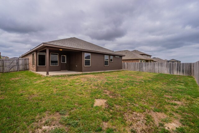 back of house with a lawn and a patio