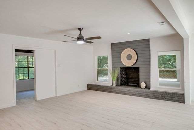 unfurnished living room featuring ceiling fan, light hardwood / wood-style flooring, and a brick fireplace