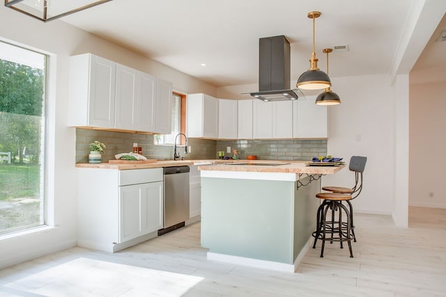 kitchen featuring island range hood, backsplash, white cabinetry, and stainless steel dishwasher