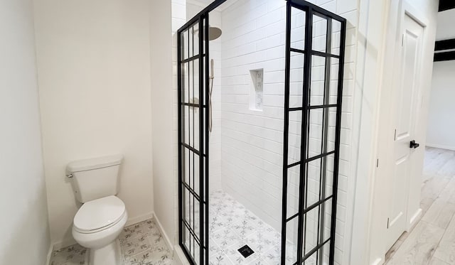 bathroom with hardwood / wood-style floors, walk in shower, and toilet