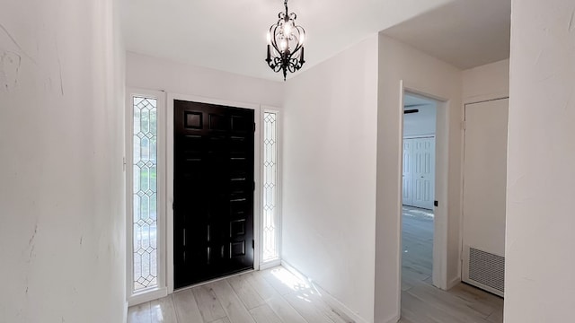 foyer entrance featuring light hardwood / wood-style flooring and a chandelier