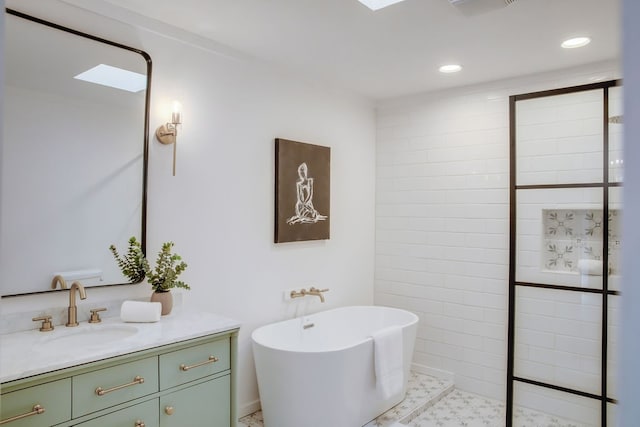 bathroom featuring vanity, a skylight, a bathtub, and tile patterned flooring