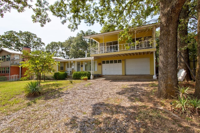 view of front of house featuring a balcony, a garage, and a front yard