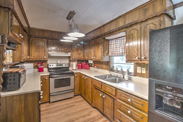 kitchen with light wood-type flooring, under cabinet range hood, a sink, stainless steel electric stove, and light countertops