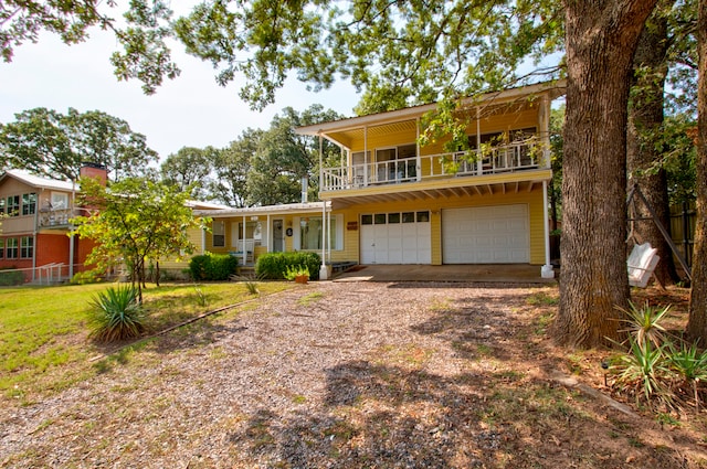 view of front of property featuring a front lawn, a garage, and a balcony