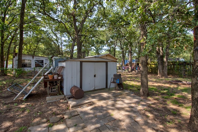 view of shed featuring fence