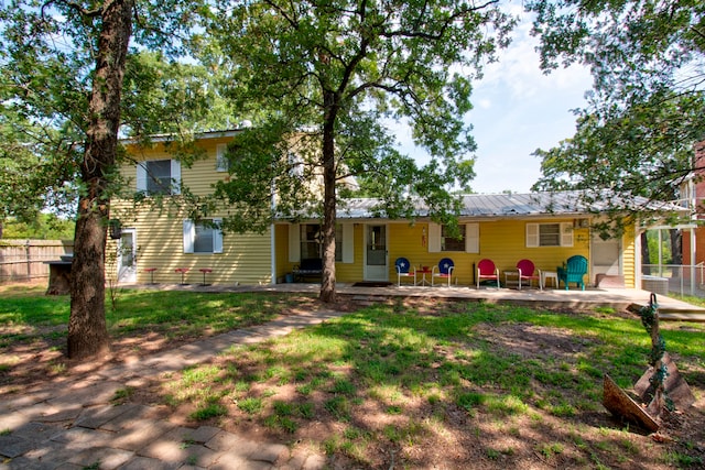 rear view of house with a lawn and a patio area