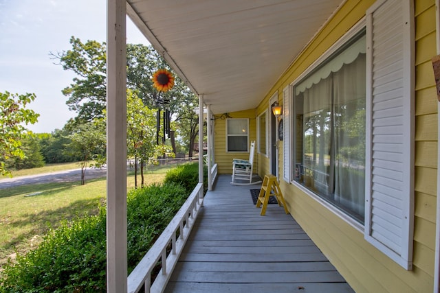 deck with a porch and a yard