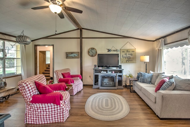 living room with lofted ceiling with beams, wood-type flooring, ornamental molding, and ceiling fan