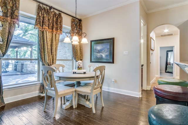 dining space with dark wood-type flooring, a notable chandelier, and ornamental molding