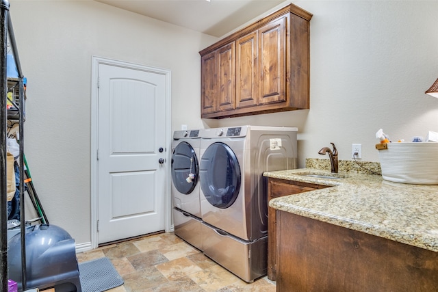 laundry area with washer and dryer, cabinets, and sink