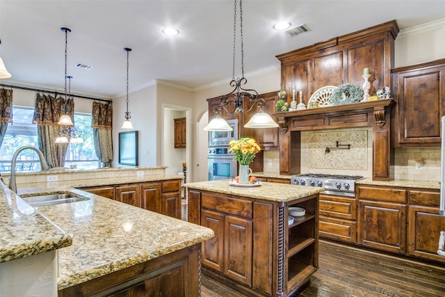 kitchen with pendant lighting, a center island, dark hardwood / wood-style floors, and sink