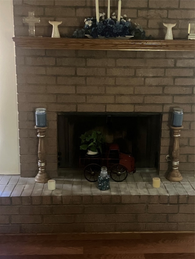 interior details with hardwood / wood-style flooring and a brick fireplace