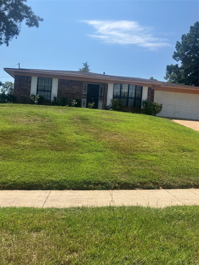 single story home featuring a front lawn and a garage