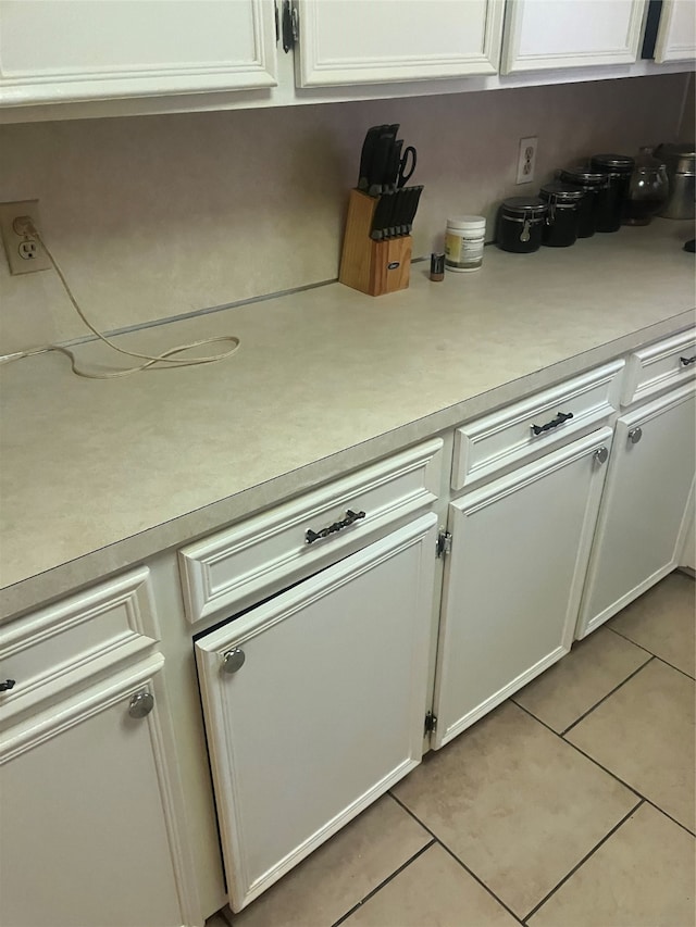 kitchen with light tile patterned flooring and white cabinets