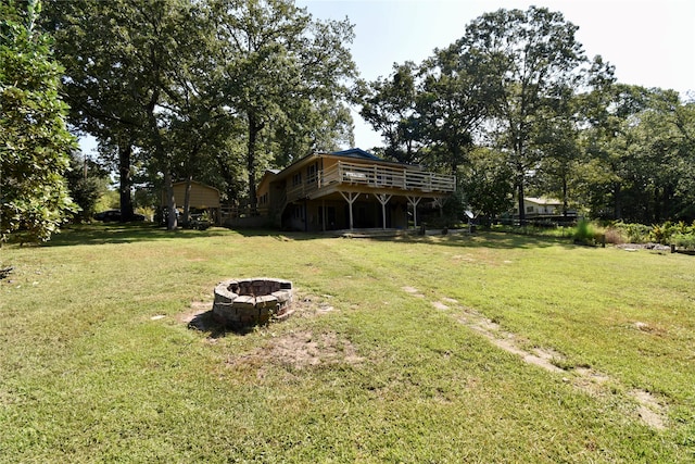 view of yard with a deck and an outdoor fire pit