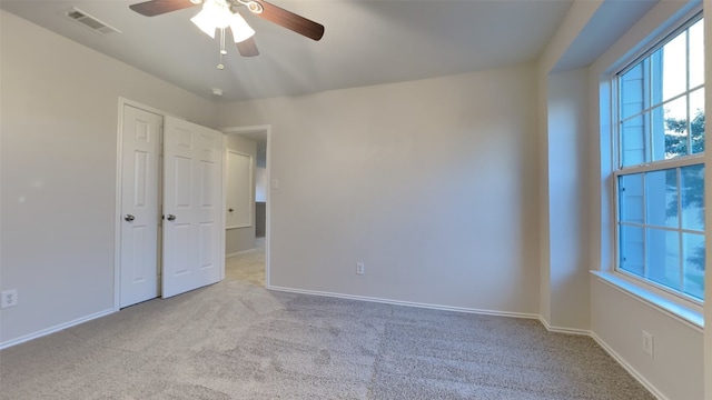 carpeted spare room featuring ceiling fan