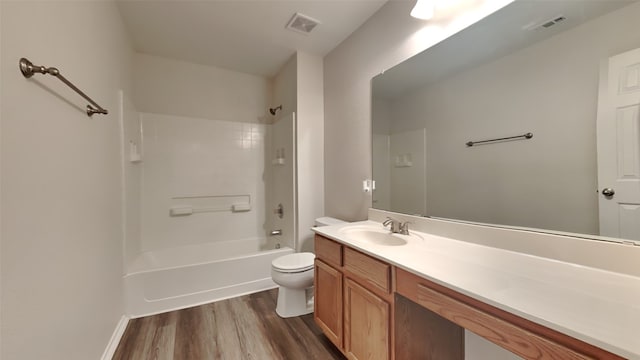 bathroom with toilet, visible vents, wood finished floors, and vanity