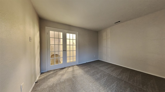 spare room with dark carpet and french doors