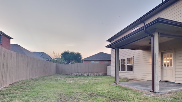 yard at dusk featuring a patio area