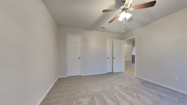 unfurnished bedroom with light carpet, ceiling fan, visible vents, and baseboards