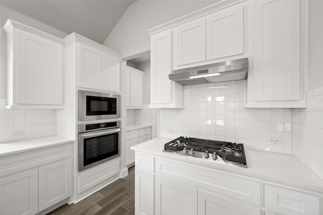 kitchen featuring appliances with stainless steel finishes, dark wood-type flooring, decorative backsplash, and white cabinets