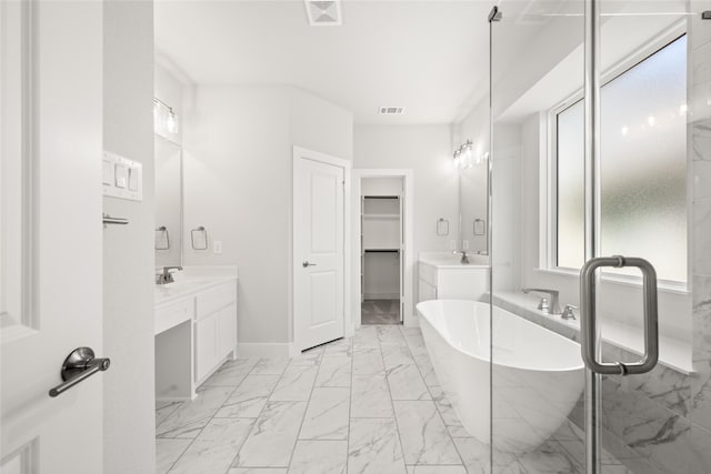 bathroom featuring tile patterned floors, vanity, and a tub to relax in