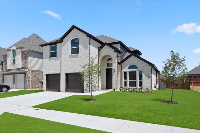 french country style house featuring a garage and a front yard